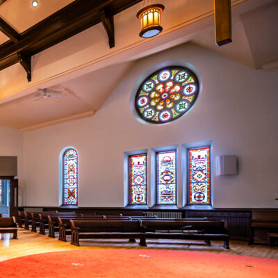 Image looking out from the stage of Cappella Performing Arts Center Sanctuary Stage showing the stained glass windows.