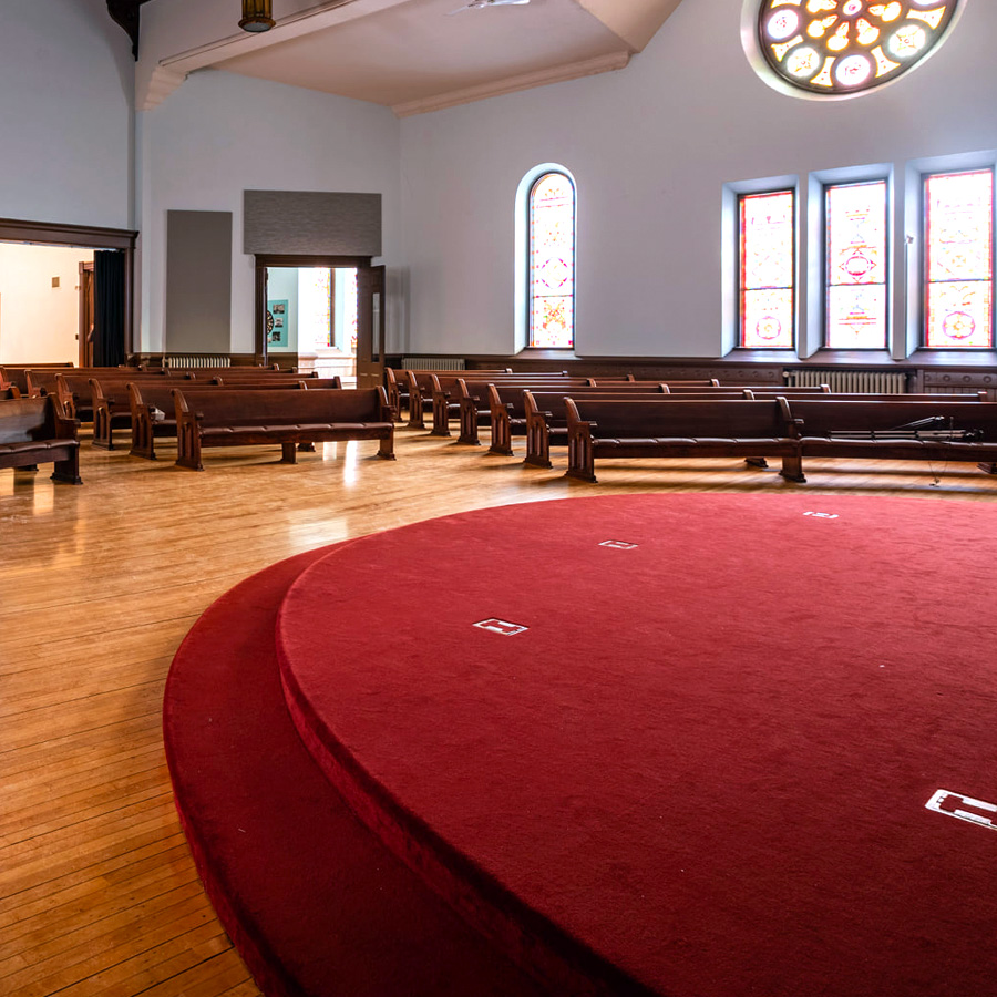 Image looking out from the stage of Cappella Performing Arts Center Sanctuary Stage showing the church pew seating.