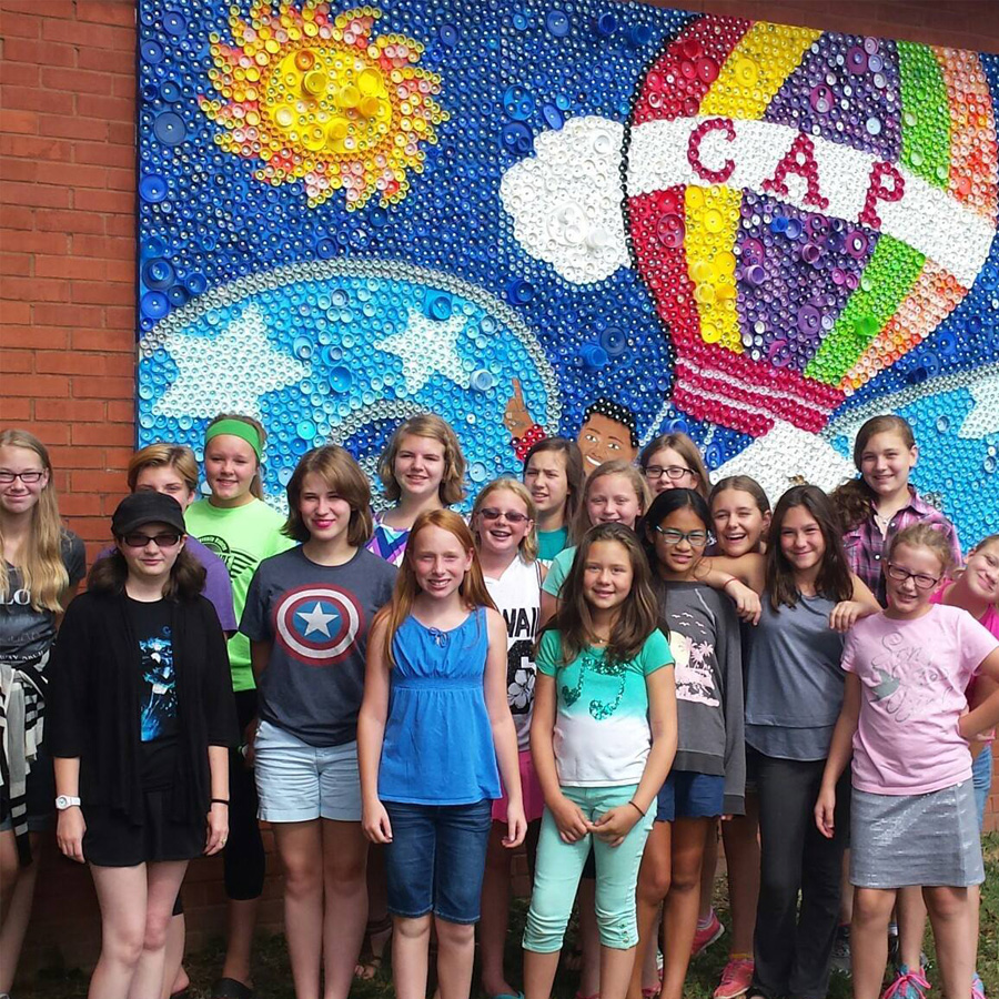 La Crosse Girlchoir posing in front of a mural during a touring trip.