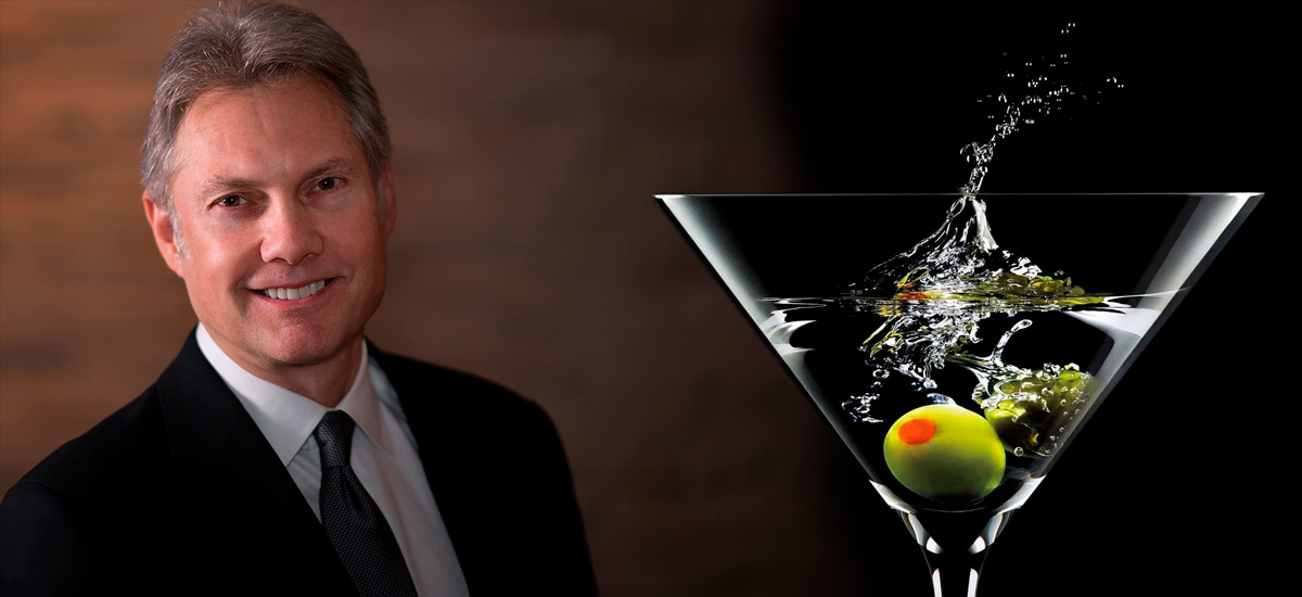 Banner image of Dan Ferris next to a martini glass with olives.